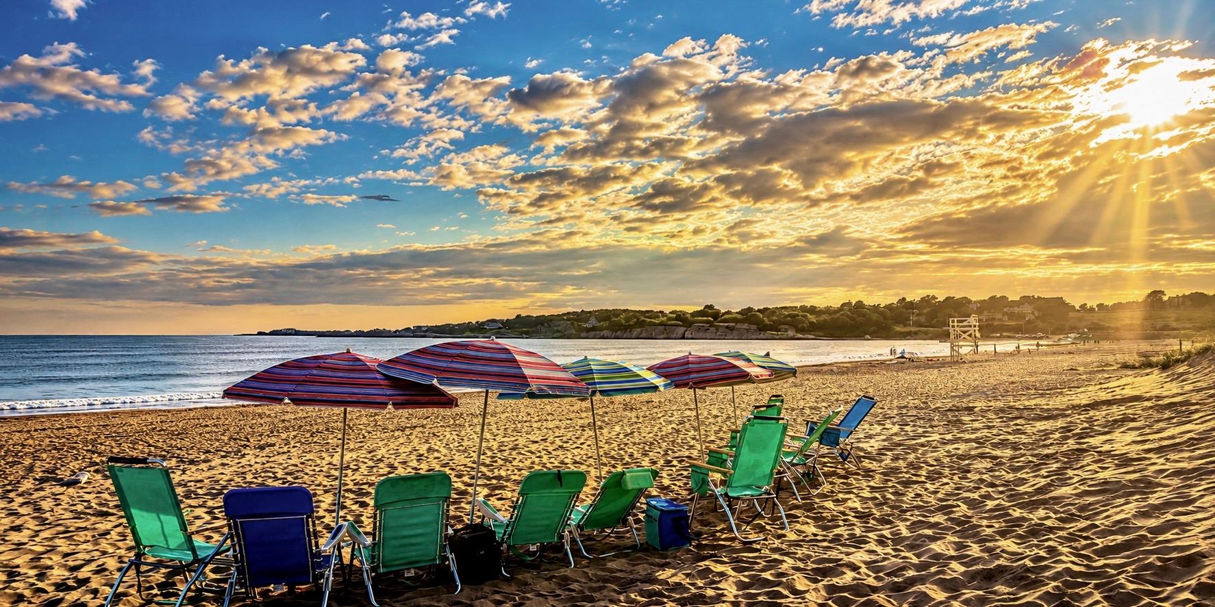 Beach chairs and umbrellas on a Rhode Island beach at golden hour